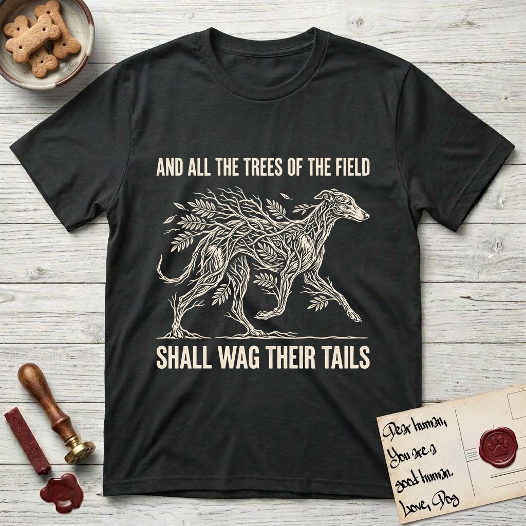 Trees of the Field Greyhound T-Shirt flat lay in Black, featuring a vintage woodcut illustration of a Greyhound formed of ash branches with streaming leaves, mid-stride, with the words And All the Trees of the Field Shall Wag Their Tails.