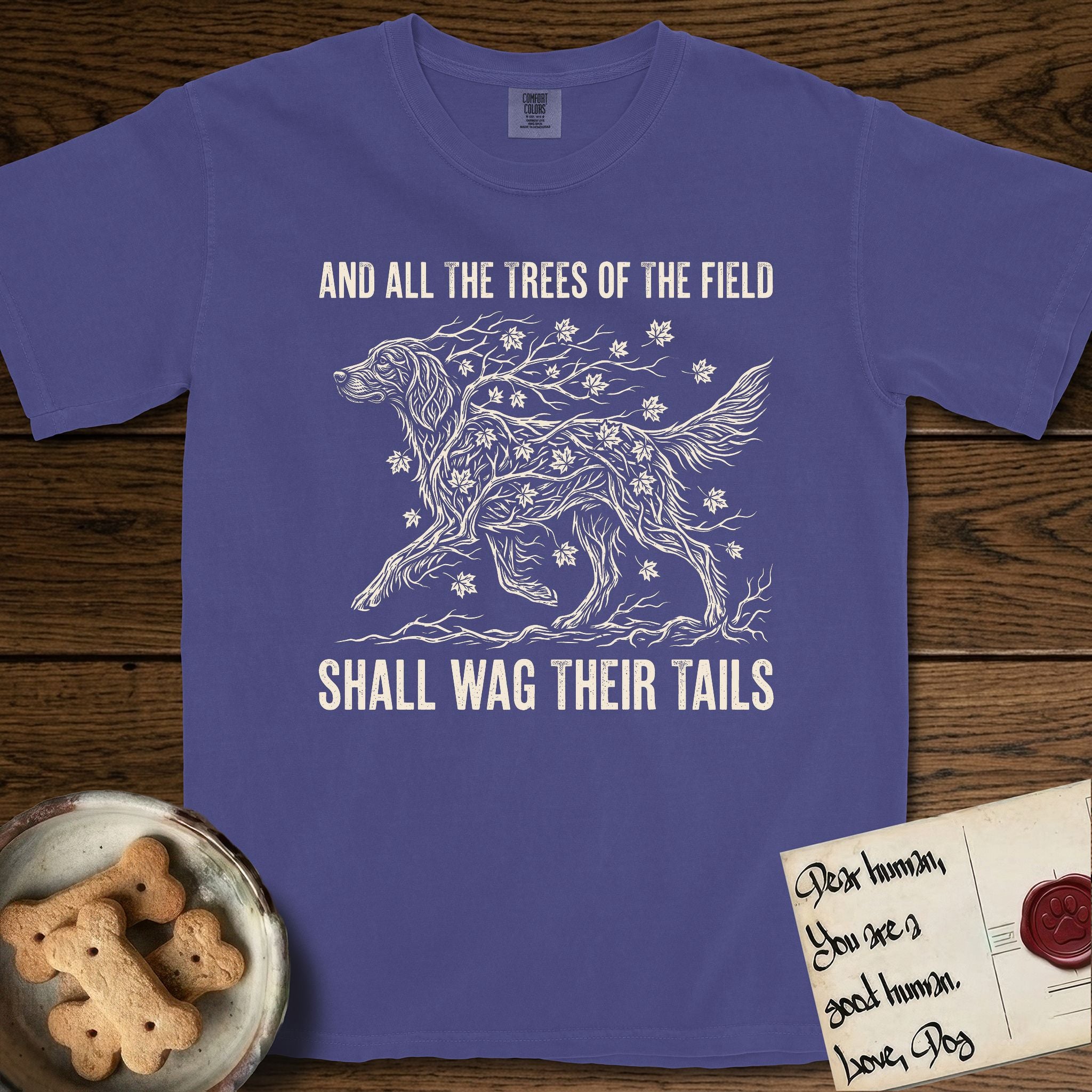 Trees of the Field Irish Setter T-Shirt flat lay in Grape, featuring a vintage woodcut illustration of an Irish Setter formed of red maple branches with autumn leaves, mid-stride, with the words And All the Trees of the Field Shall Wag Their Tails.