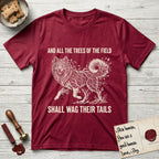 Trees of the Field Samoyed T-Shirt flat lay in Antique Cherry Red, featuring a vintage woodcut illustration of a Samoyed formed of white birch branches with catkins, mid-stride, with the words And All the Trees of the Field Shall Wag Their Tails.