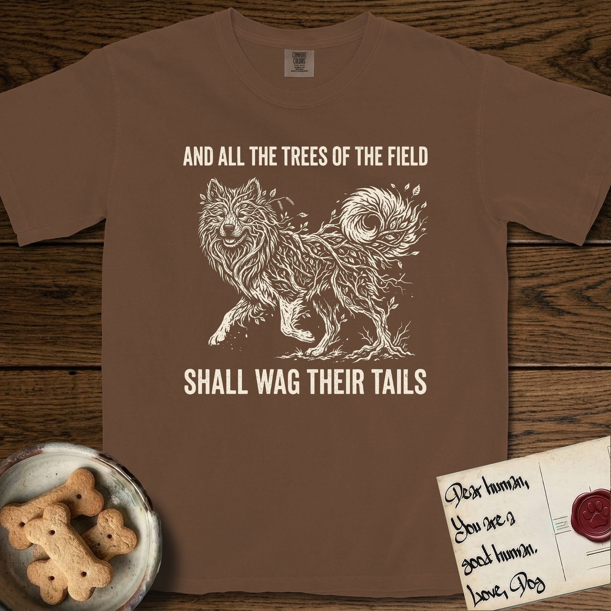 Trees of the Field Samoyed T-Shirt flat lay in Espresso, featuring a vintage woodcut illustration of a Samoyed formed of white birch branches with catkins, mid-stride, with the words And All the Trees of the Field Shall Wag Their Tails.