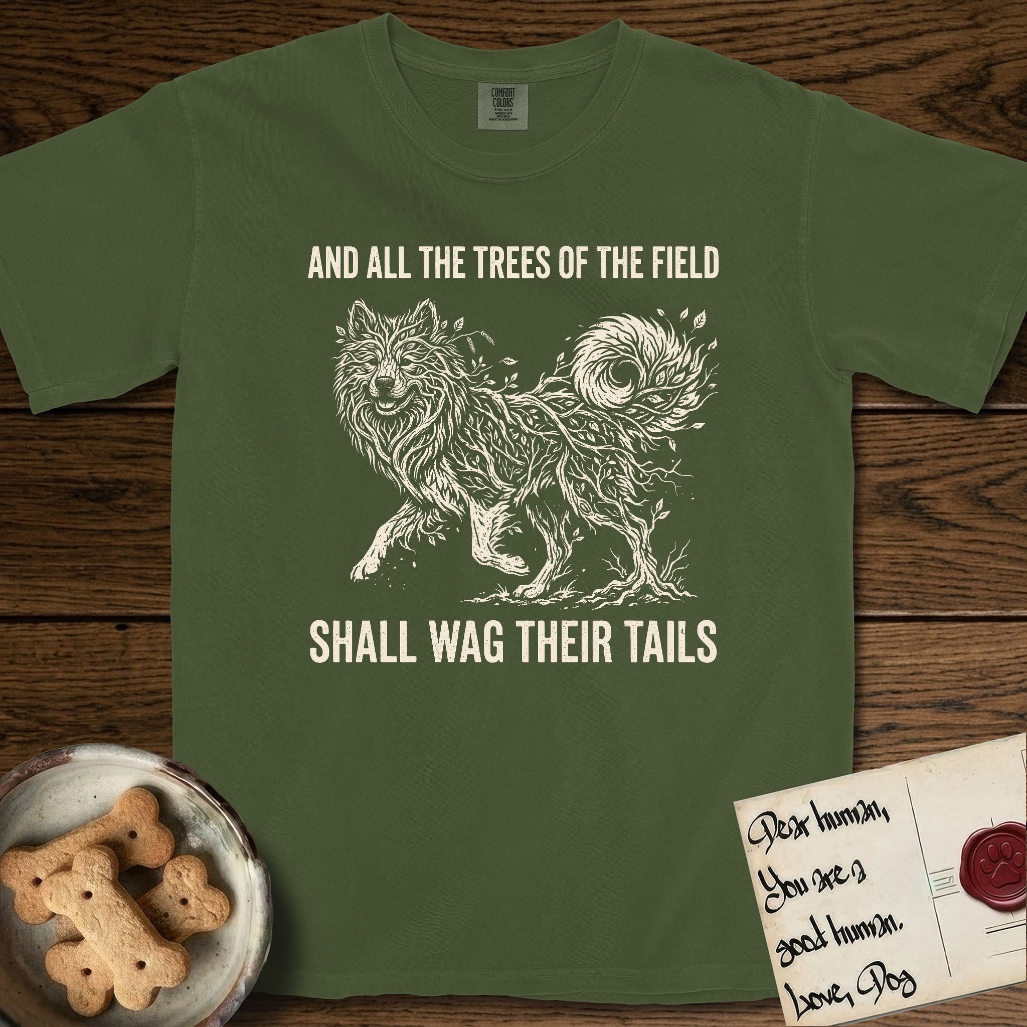 Trees of the Field Samoyed T-Shirt flat lay in Hemp, featuring a vintage woodcut illustration of a Samoyed formed of white birch branches with catkins, mid-stride, with the words And All the Trees of the Field Shall Wag Their Tails.