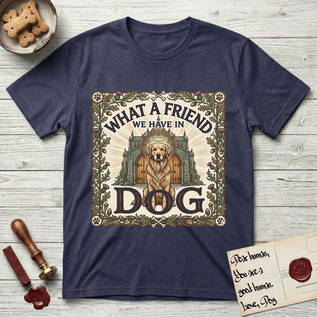 What a Friend We Have in Dog T-Shirt flat lay in Navy, featuring an Arts and Crafts tapestry illustration of a haloed Golden Retriever seated before a monastery, framed by an oak-leaf, acorn, and thistle border, with the word DOG below.