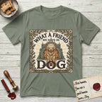 What a Friend We Have in Dog T-Shirt flat lay in Sage, featuring an Arts and Crafts tapestry illustration of a haloed Golden Retriever seated before a monastery, framed by an oak-leaf, acorn, and thistle border, with the word DOG below.