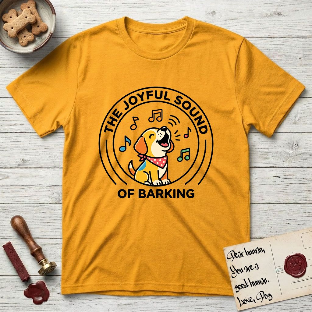 The Joyful Sound of Barking T-Shirt flat lay in Gold, featuring a flat vector cartoon emblem of a happy puppy with lifted ears surrounded by musical notes, ringed by the words The Joyful Sound of Barking.