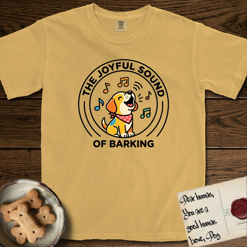 The Joyful Sound of Barking T-Shirt flat lay in Mustard, featuring a flat vector cartoon emblem of a happy puppy with lifted ears surrounded by musical notes, ringed by the words The Joyful Sound of Barking.