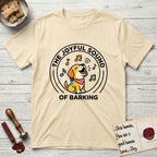The Joyful Sound of Barking T-Shirt flat lay in Natural, featuring a flat vector cartoon emblem of a happy puppy with lifted ears surrounded by musical notes, ringed by the words The Joyful Sound of Barking.
