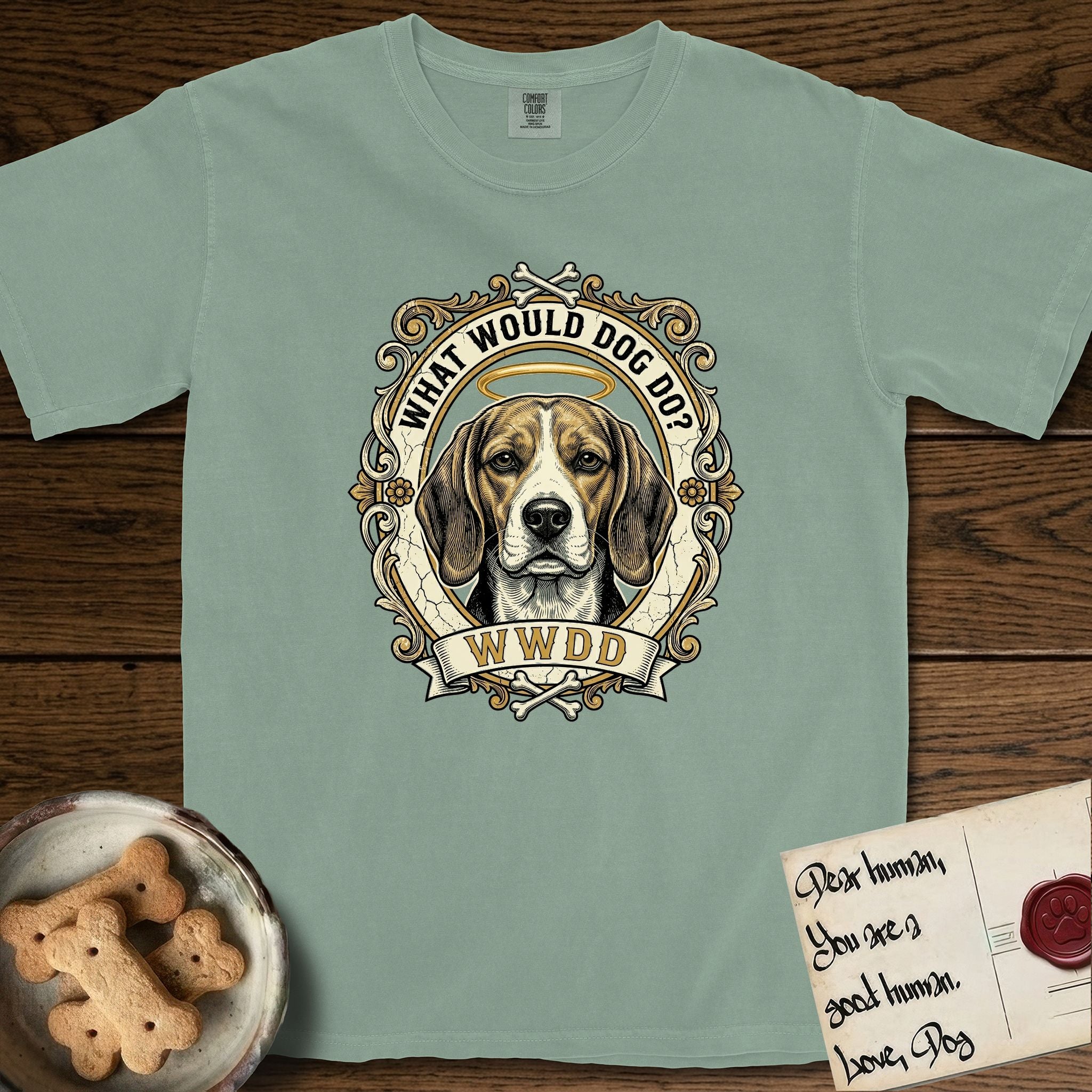 What Would Dog Do Beagle T-Shirt flat lay in Bay, featuring a baroque scrollwork gold portrait medallion of a haloed Beagle with the question What Would Dog Do.