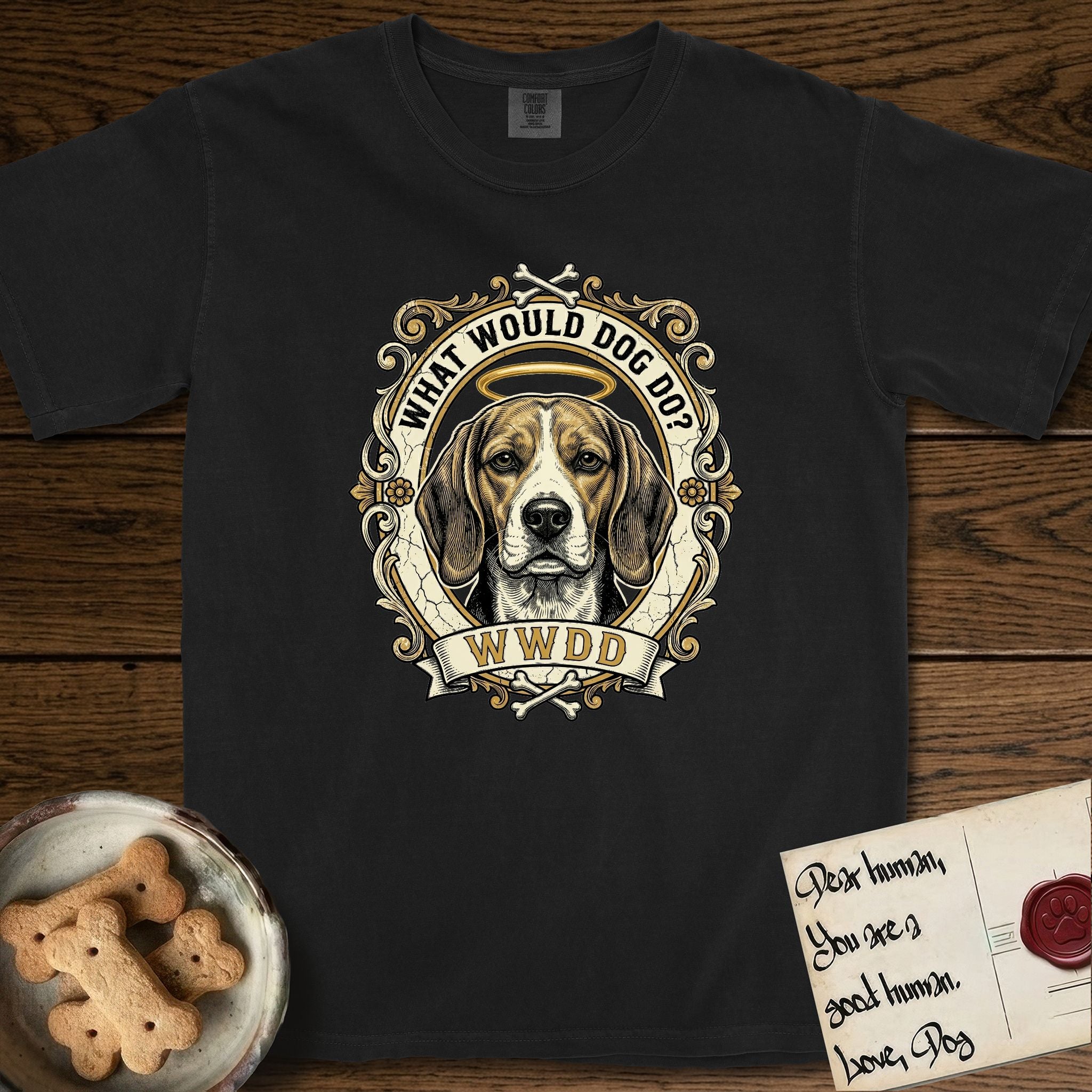 What Would Dog Do Beagle T-Shirt flat lay in Black, featuring a baroque scrollwork gold portrait medallion of a haloed Beagle with the question What Would Dog Do.