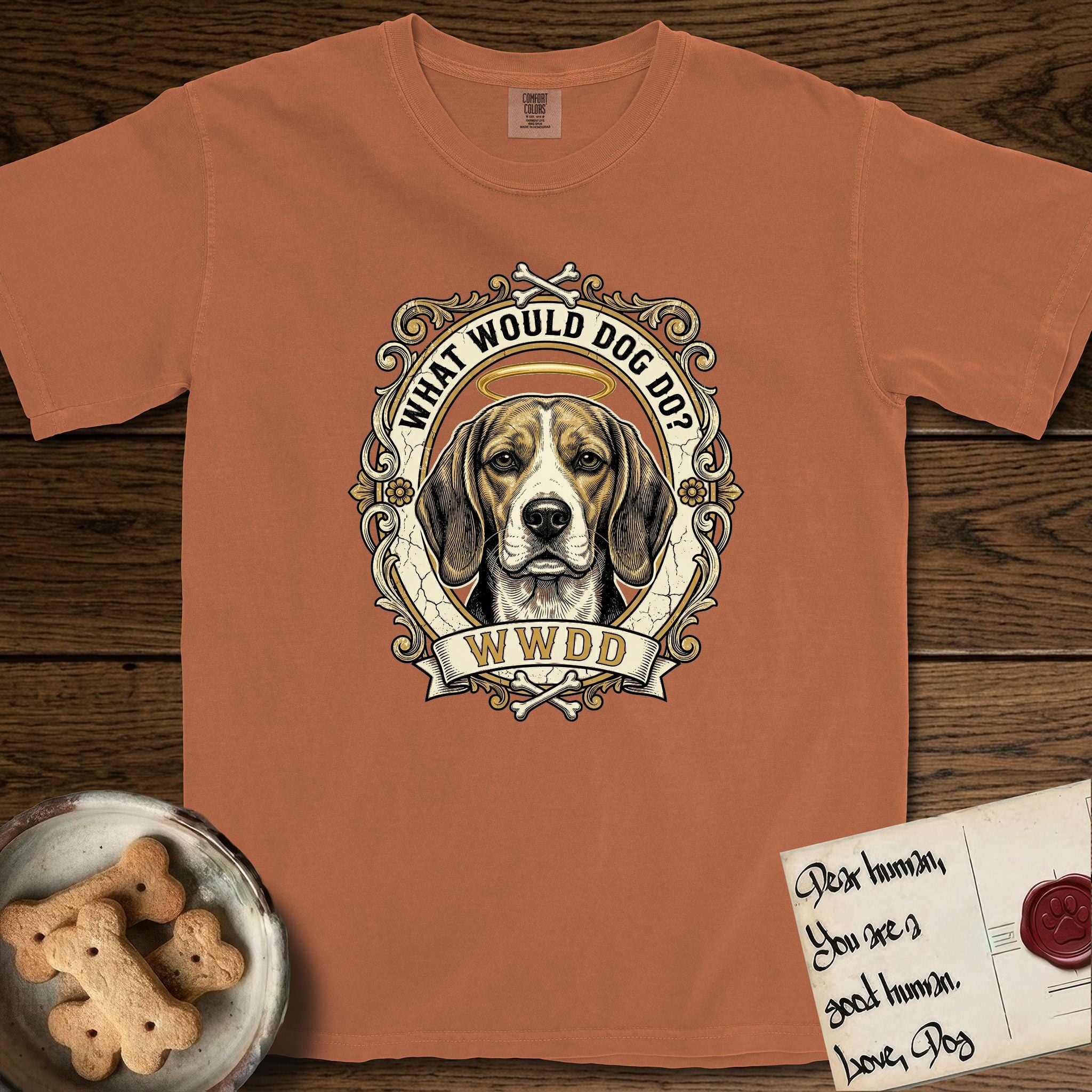 What Would Dog Do Beagle T-Shirt flat lay in Yam, featuring a baroque scrollwork gold portrait medallion of a haloed Beagle with the question What Would Dog Do.