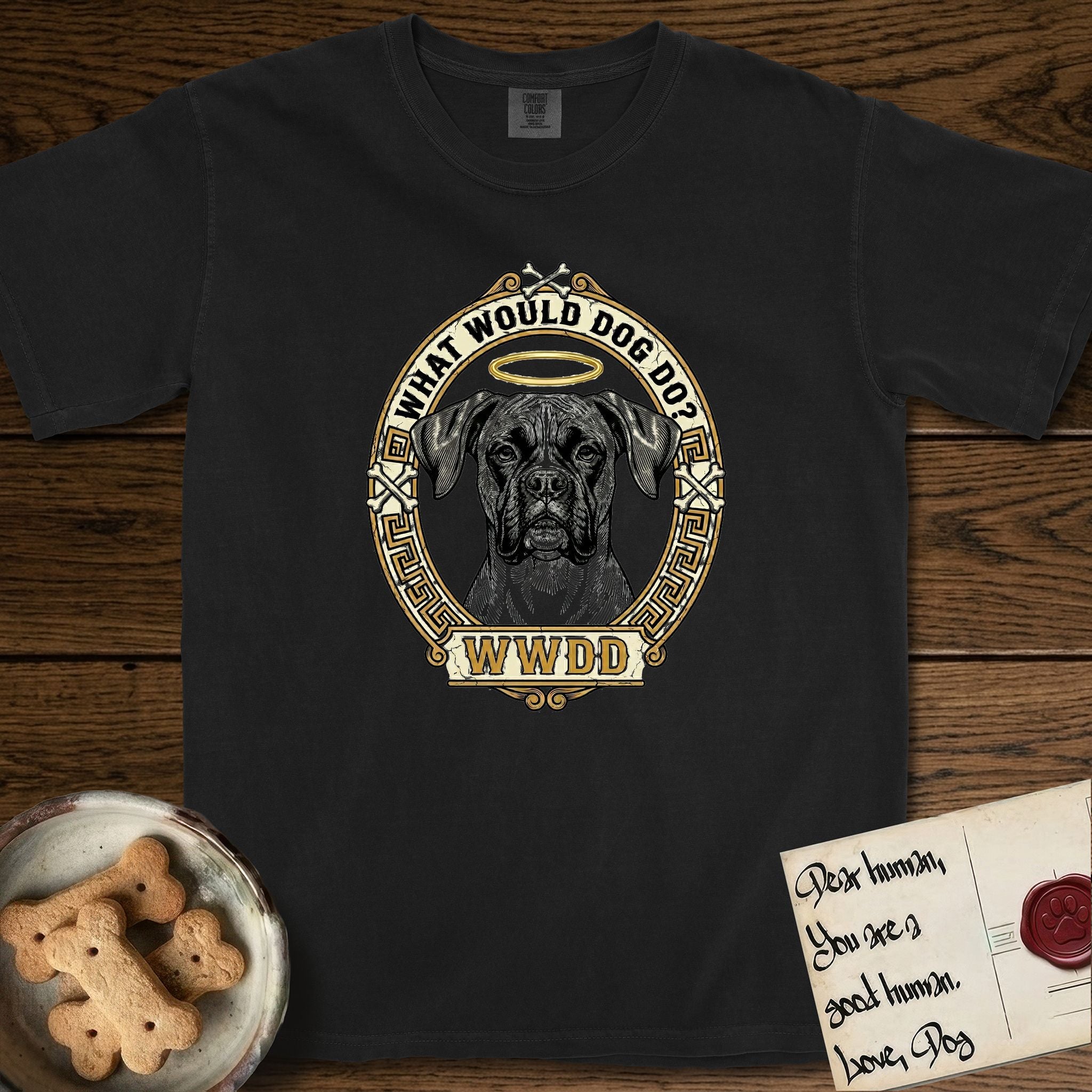 What Would Dog Do Boxer T-Shirt flat lay in Black, featuring a Greek-key bordered gold portrait medallion of a haloed Boxer with natural uncropped ears and the question What Would Dog Do.