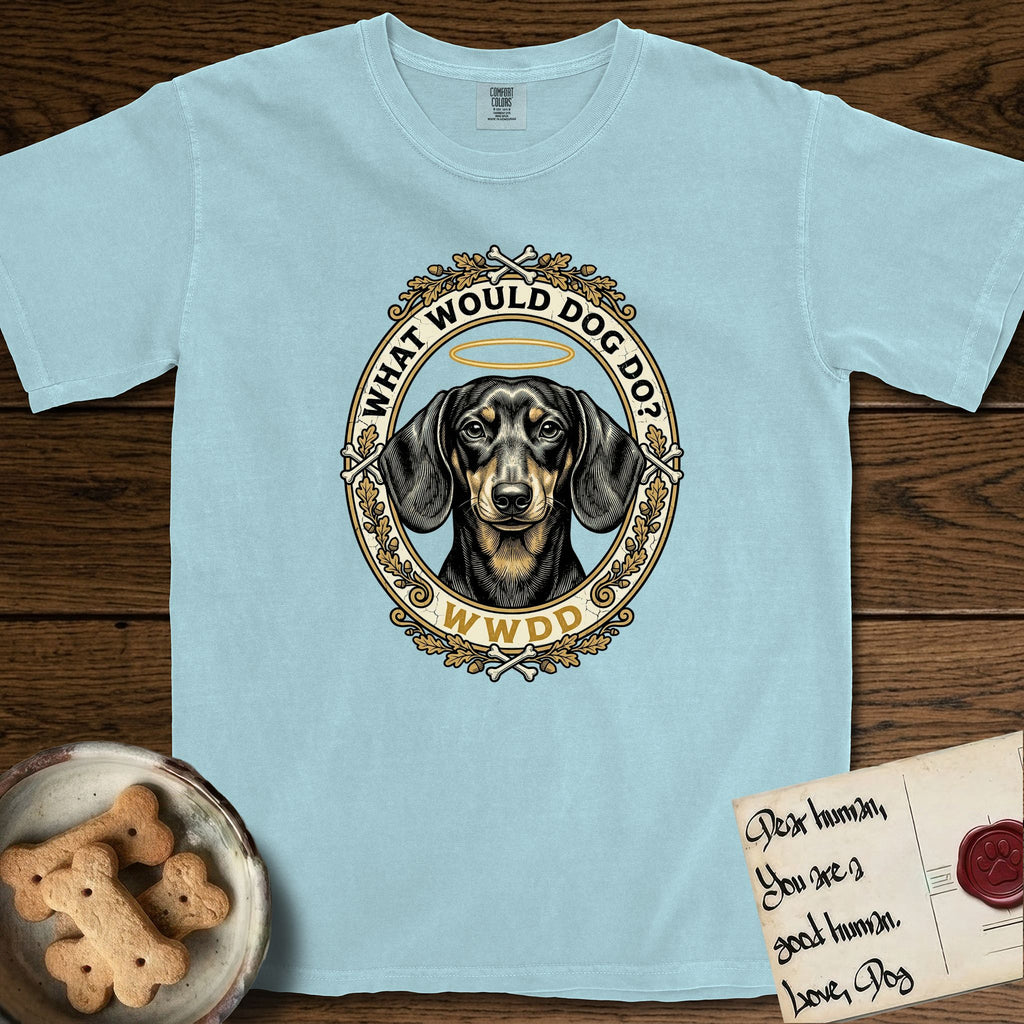 What Would Dog Do Dachshund T-Shirt flat lay in Chambray, featuring an oak-leaf and acorn framed gold portrait medallion of a haloed Dachshund with the question What Would Dog Do.