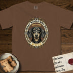 What Would Dog Do Dachshund T-Shirt flat lay in Espresso, featuring an oak-leaf and acorn framed gold portrait medallion of a haloed Dachshund with the question What Would Dog Do.