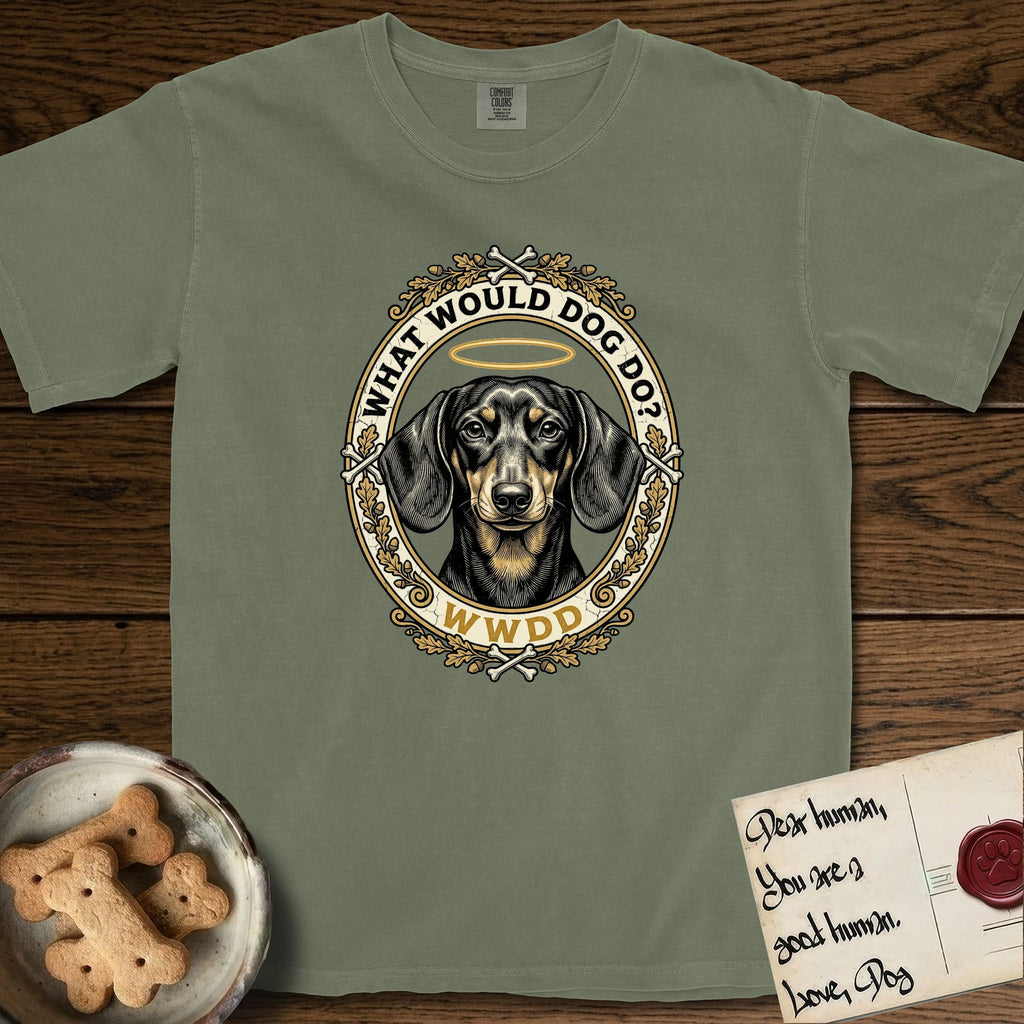 What Would Dog Do Dachshund T-Shirt flat lay in Sage, featuring an oak-leaf and acorn framed gold portrait medallion of a haloed Dachshund with the question What Would Dog Do.