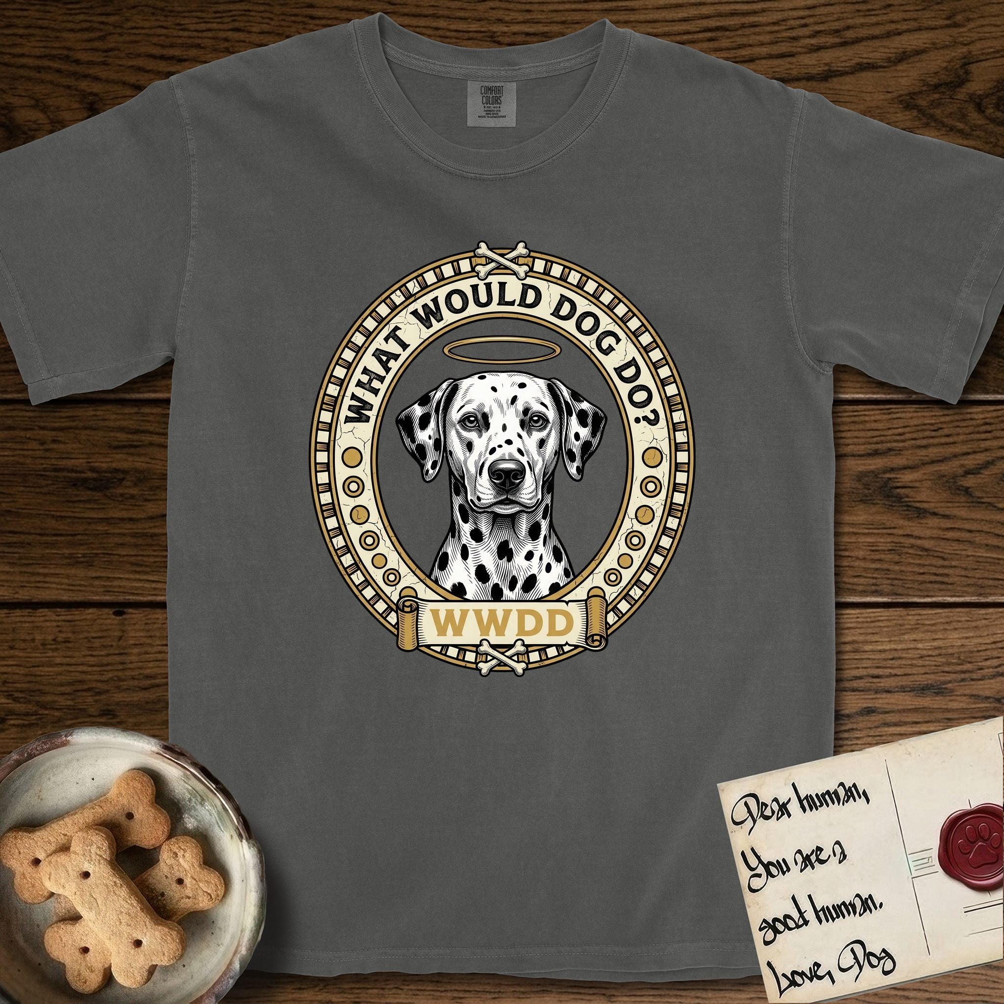 What Would Dog Do Dalmatian T-Shirt flat lay in Pepper, featuring a vintage gold portrait medallion of a haloed Dalmatian in an engraved coin-style dotted border with the question What Would Dog Do.