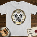What Would Dog Do Dalmatian T-Shirt flat lay in White, featuring a vintage gold portrait medallion of a haloed Dalmatian in an engraved coin-style dotted border with the question What Would Dog Do.
