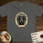 What Would Dog Do Doberman T-Shirt flat lay in Pepper, featuring a fleur-de-lis framed gold portrait medallion of a haloed Doberman with natural uncropped ears and the question What Would Dog Do.