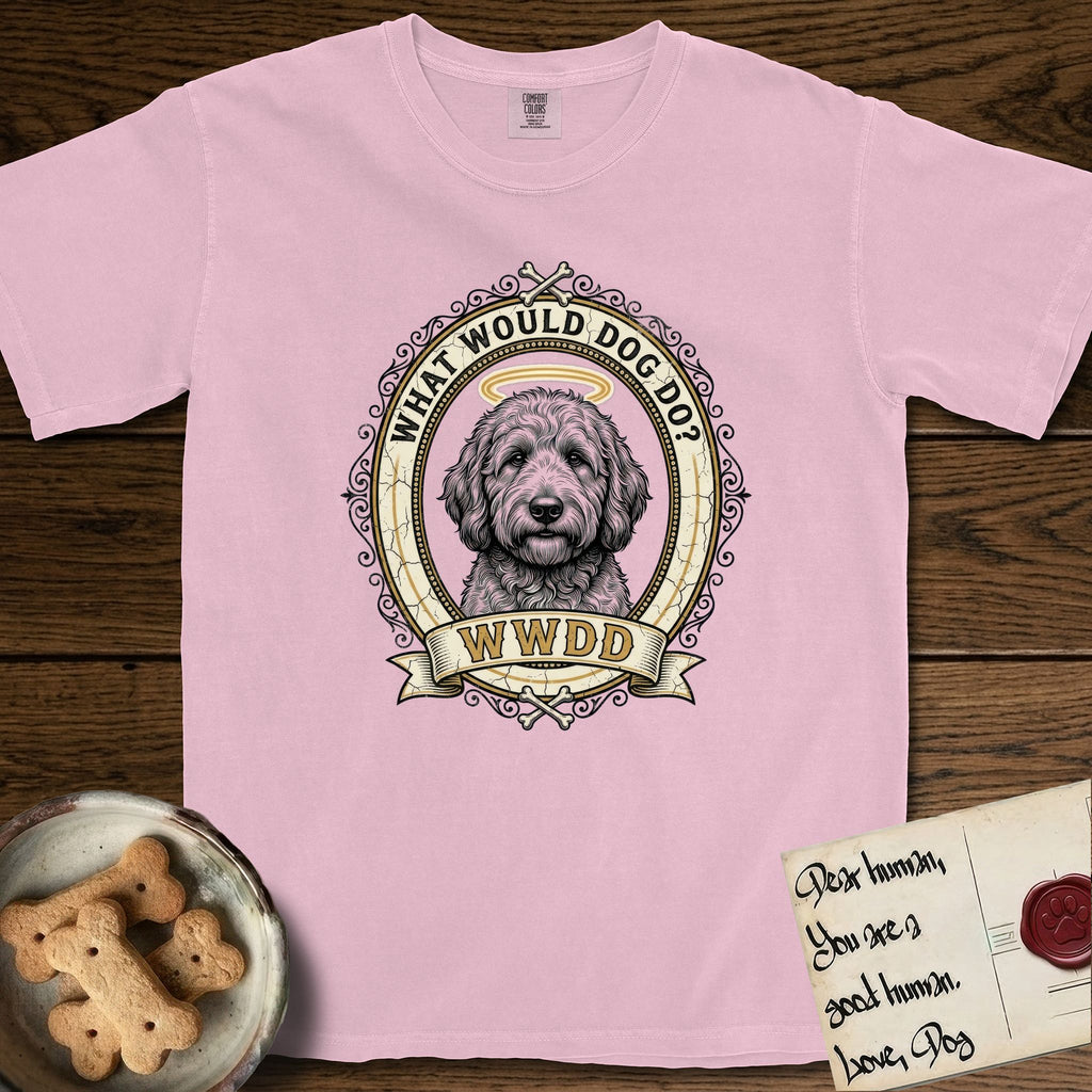 What Would Dog Do Goldendoodle T-Shirt flat lay in Blossom, featuring an ornate scrollwork gold portrait medallion of a haloed Goldendoodle with the question What Would Dog Do.