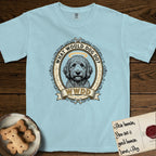 What Would Dog Do Goldendoodle T-Shirt flat lay in Chambray, featuring an ornate scrollwork gold portrait medallion of a haloed Goldendoodle with the question What Would Dog Do.
