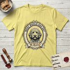 What Would Dog Do Goldendoodle T-Shirt flat lay in Cornsilk, featuring an ornate scrollwork gold portrait medallion of a haloed Goldendoodle with the question What Would Dog Do.