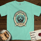 What Would Dog Do Goldendoodle T-Shirt flat lay in Island Reef, featuring an ornate scrollwork gold portrait medallion of a haloed Goldendoodle with the question What Would Dog Do.