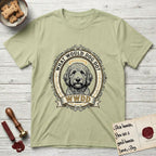 What Would Dog Do Goldendoodle T-Shirt flat lay in Pistachio, featuring an ornate scrollwork gold portrait medallion of a haloed Goldendoodle with the question What Would Dog Do.