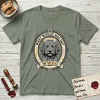 What Would Dog Do Goldendoodle T-Shirt flat lay in Sage, featuring an ornate scrollwork gold portrait medallion of a haloed Goldendoodle with the question What Would Dog Do.