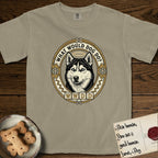 What Would Dog Do Husky T-Shirt flat lay in Khaki, featuring a vintage gold portrait medallion of a haloed blue-eyed Husky in a Nordic snowflake border with the question What Would Dog Do.