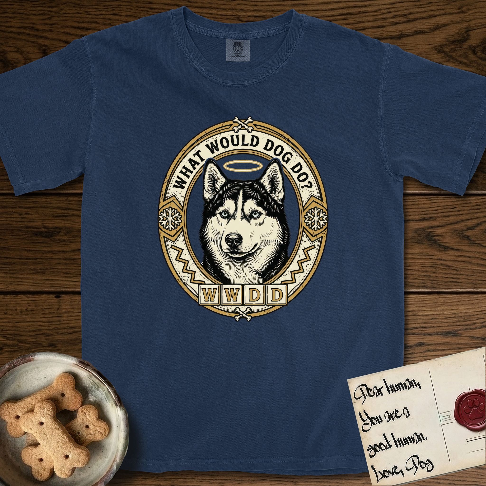 What Would Dog Do Husky T-Shirt flat lay in True Navy, featuring a vintage gold portrait medallion of a haloed blue-eyed Husky in a Nordic snowflake border with the question What Would Dog Do.