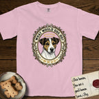 What Would Dog Do Jack Russell T-Shirt flat lay in Blossom, featuring a vintage gold portrait medallion of a haloed Jack Russell in a wreath of thorned branches and wildflowers with the question What Would Dog Do.