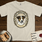 What Would Dog Do Jack Russell T-Shirt flat lay in Ivory, featuring a vintage gold portrait medallion of a haloed Jack Russell in a wreath of thorned branches and wildflowers with the question What Would Dog Do.