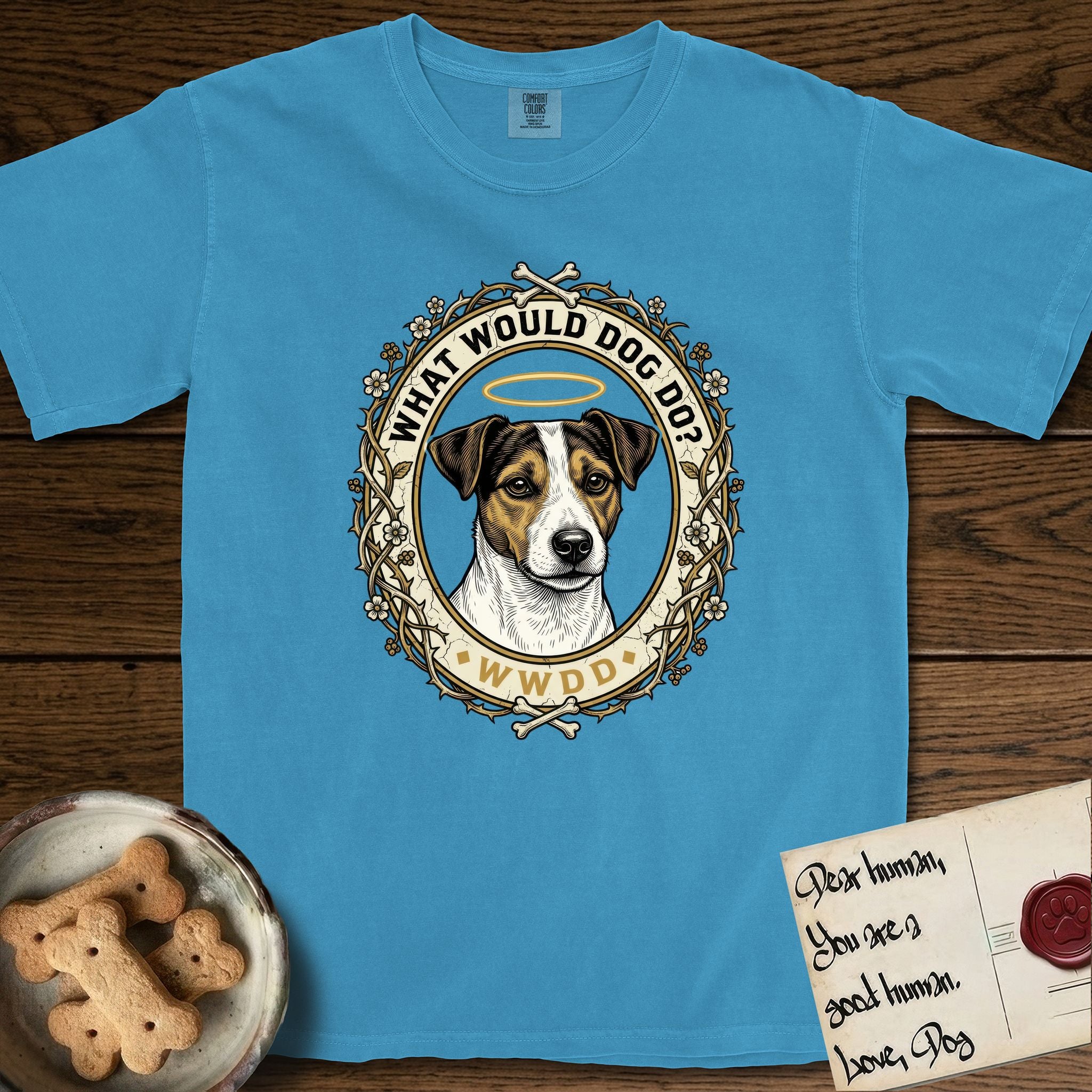 What Would Dog Do Jack Russell T-Shirt flat lay in Royal Caribe, featuring a vintage gold portrait medallion of a haloed Jack Russell in a wreath of thorned branches and wildflowers with the question What Would Dog Do.