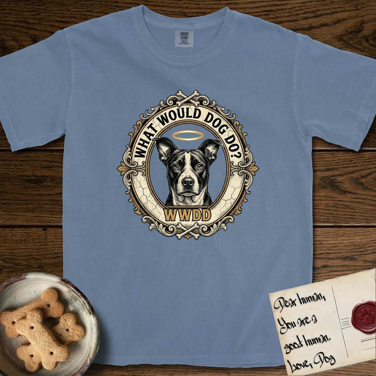 What Would Dog Do Lobo T-Shirt flat lay in Blue Jean, featuring a baroque gold ornate portrait medallion of haloed Lobo with the question What Would Dog Do and a small PDX inscription.