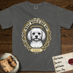 What Would Dog Do Maltese T-Shirt flat lay in Pepper, featuring a vintage gold portrait medallion of a haloed white Maltese in a Celtic knotwork and rope border with the question What Would Dog Do.