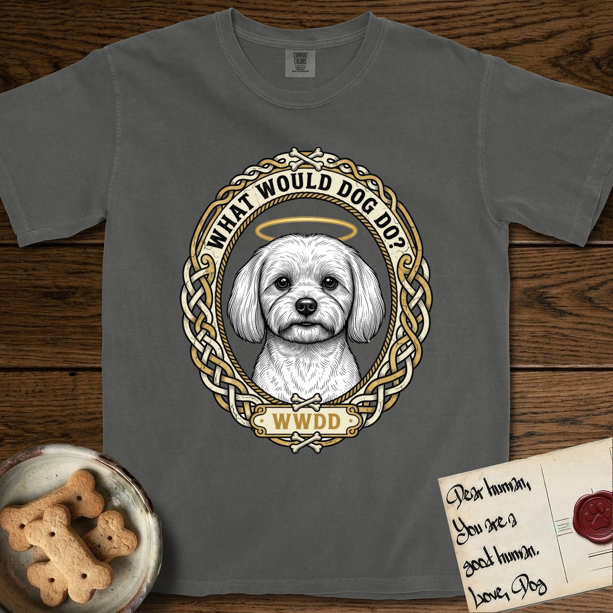 What Would Dog Do Maltese T-Shirt flat lay in Pepper, featuring a vintage gold portrait medallion of a haloed white Maltese in a Celtic knotwork and rope border with the question What Would Dog Do.