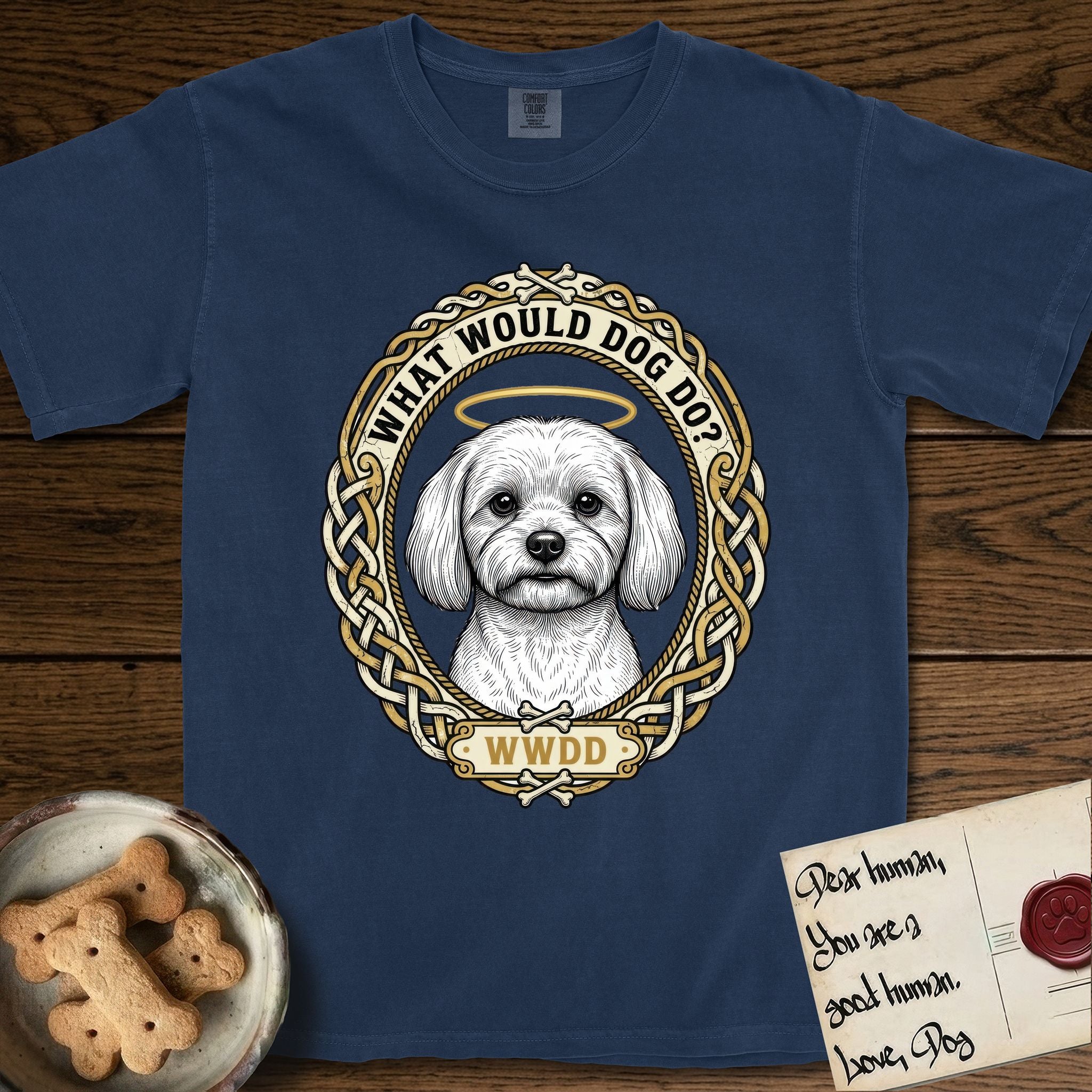 What Would Dog Do Maltese T-Shirt flat lay in True Navy, featuring a vintage gold portrait medallion of a haloed white Maltese in a Celtic knotwork and rope border with the question What Would Dog Do.