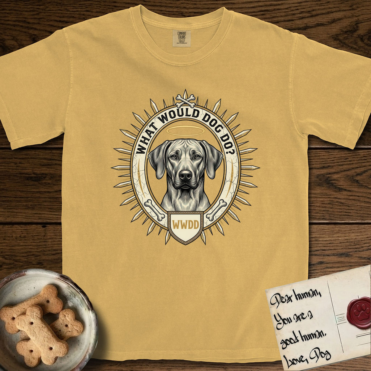 What Would Dog Do Rhodesian Ridgeback T-Shirt flat lay in Mustard, featuring a vintage gold portrait medallion of a haloed Rhodesian Ridgeback ringed by radiating sunburst spikes with the question What Would Dog Do.