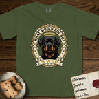 What Would Dog Do Rottweiler T-Shirt flat lay in Hemp, featuring a vintage gold portrait medallion of a haloed Rottweiler framed by studded leather collar straps and buckles with the question What Would Dog Do.