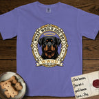 What Would Dog Do Rottweiler T-Shirt flat lay in Violet, featuring a vintage gold portrait medallion of a haloed Rottweiler framed by studded leather collar straps and buckles with the question What Would Dog Do.