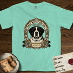 What Would Dog Do Saint Bernard T-Shirt flat lay in Island Reef, featuring a vintage gold portrait medallion of a haloed Saint Bernard in an alpine laurel wreath with edelweiss blossoms and the question What Would Dog Do.
