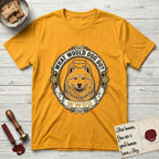 What Would Dog Do Samoyed T-Shirt flat lay in Gold, featuring a rope-twist framed gold portrait medallion of a haloed Samoyed with the question What Would Dog Do.