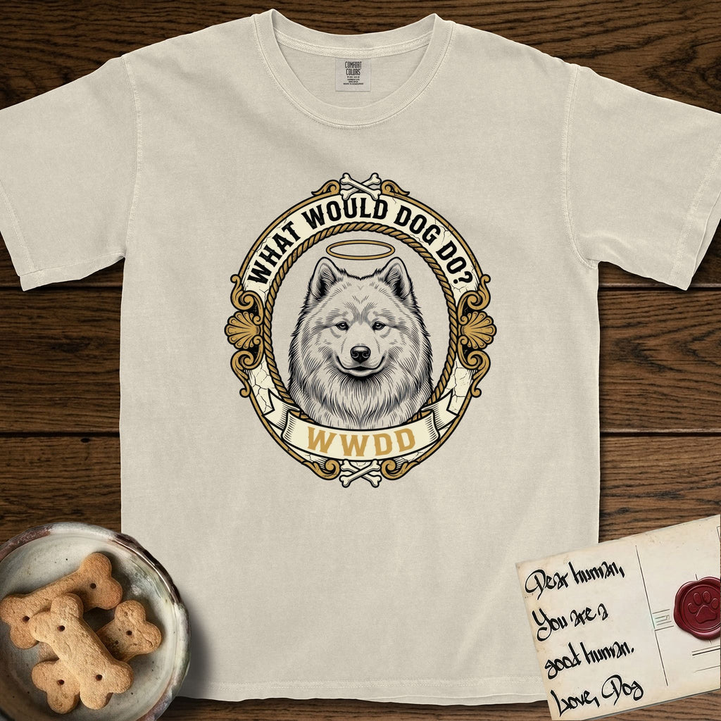 What Would Dog Do Samoyed T-Shirt flat lay in Ivory, featuring a rope-twist framed gold portrait medallion of a haloed Samoyed with the question What Would Dog Do.