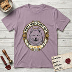 What Would Dog Do Samoyed T-Shirt flat lay in Paragon, featuring a rope-twist framed gold portrait medallion of a haloed Samoyed with the question What Would Dog Do.