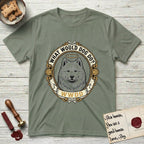 What Would Dog Do Samoyed T-Shirt flat lay in Sage, featuring a rope-twist framed gold portrait medallion of a haloed Samoyed with the question What Would Dog Do.