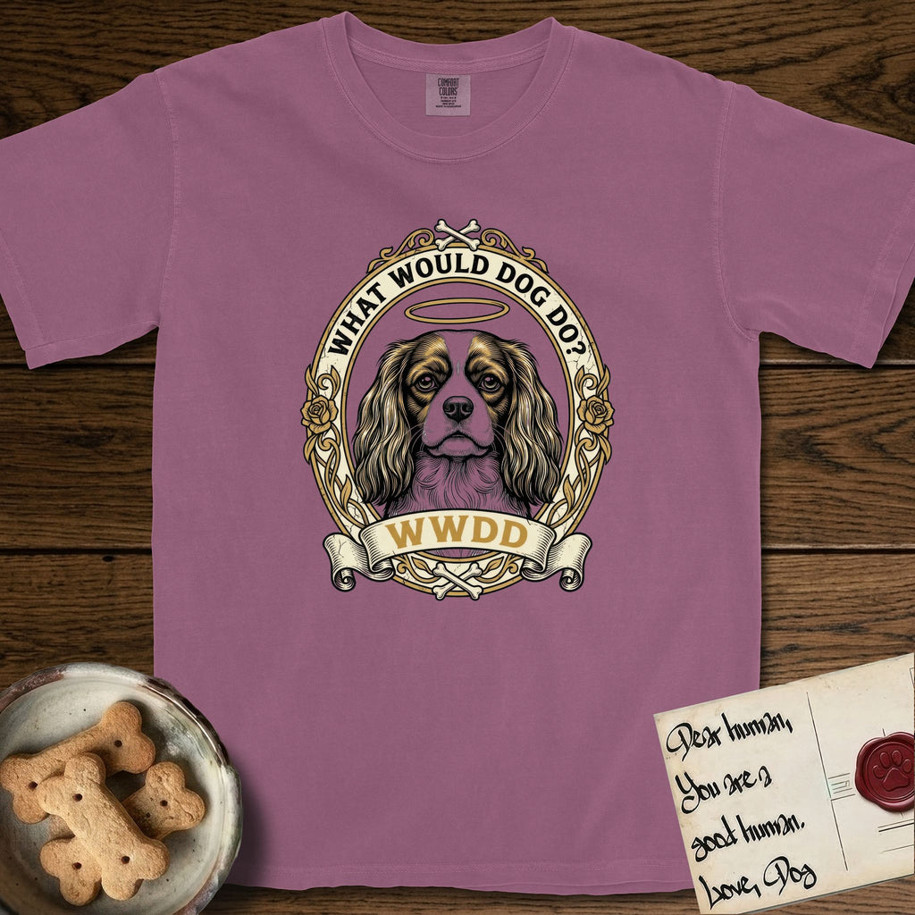 What Would Dog Do Cavalier T-Shirt flat lay in Berry, featuring a rose-bordered gold portrait medallion of a haloed Cavalier King Charles Spaniel with the question What Would Dog Do.