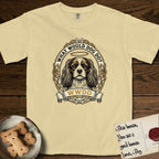 What Would Dog Do Cavalier T-Shirt flat lay in Butter, featuring a rose-bordered gold portrait medallion of a haloed Cavalier King Charles Spaniel with the question What Would Dog Do.