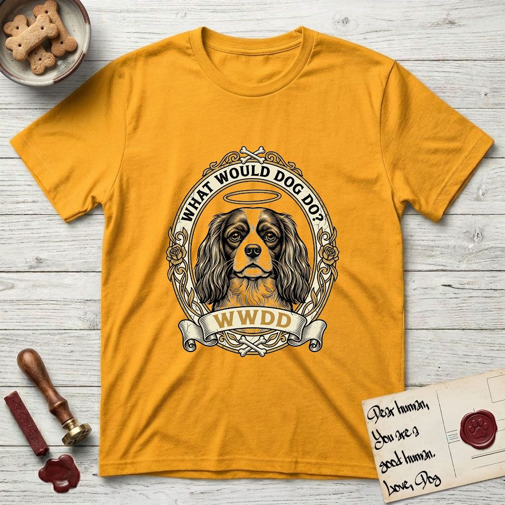 What Would Dog Do Spaniel T-Shirt flat lay in Gold, featuring a rose-bordered gold portrait medallion of a haloed Cavalier King Charles Spaniel with the question What Would Dog Do.