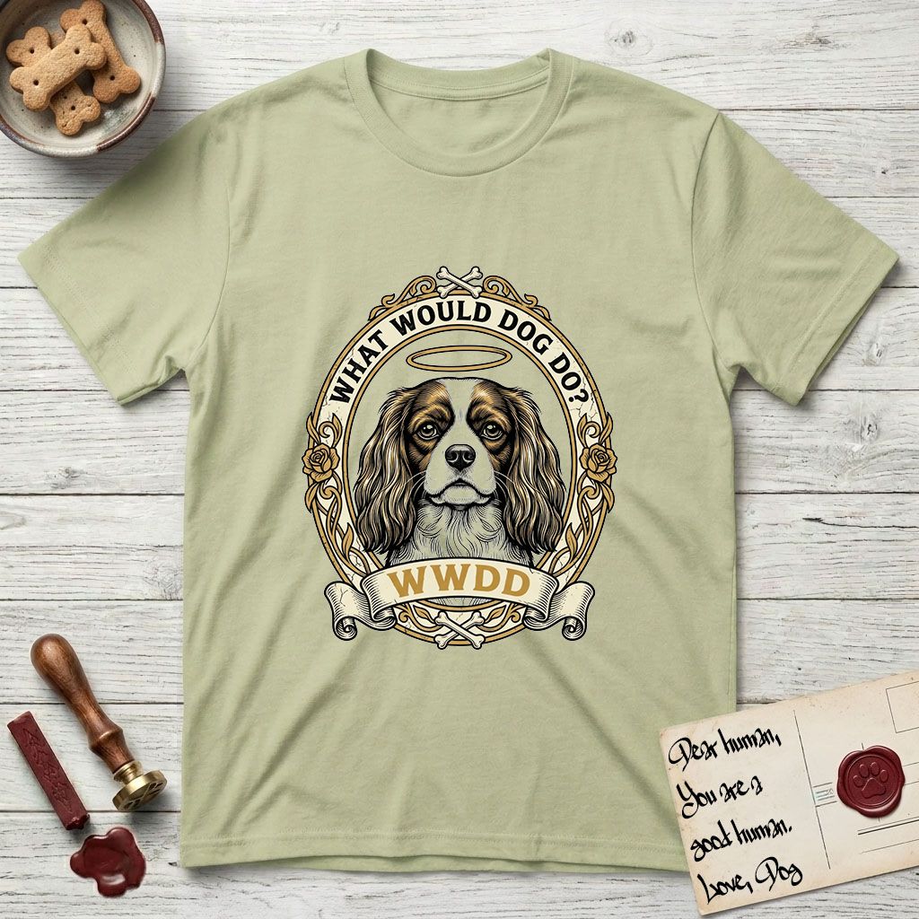 What Would Dog Do Spaniel T-Shirt flat lay in Pistachio, featuring a rose-bordered gold portrait medallion of a haloed Cavalier King Charles Spaniel with the question What Would Dog Do.