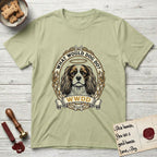 What Would Dog Do Spaniel T-Shirt flat lay in Pistachio, featuring a rose-bordered gold portrait medallion of a haloed Cavalier King Charles Spaniel with the question What Would Dog Do.