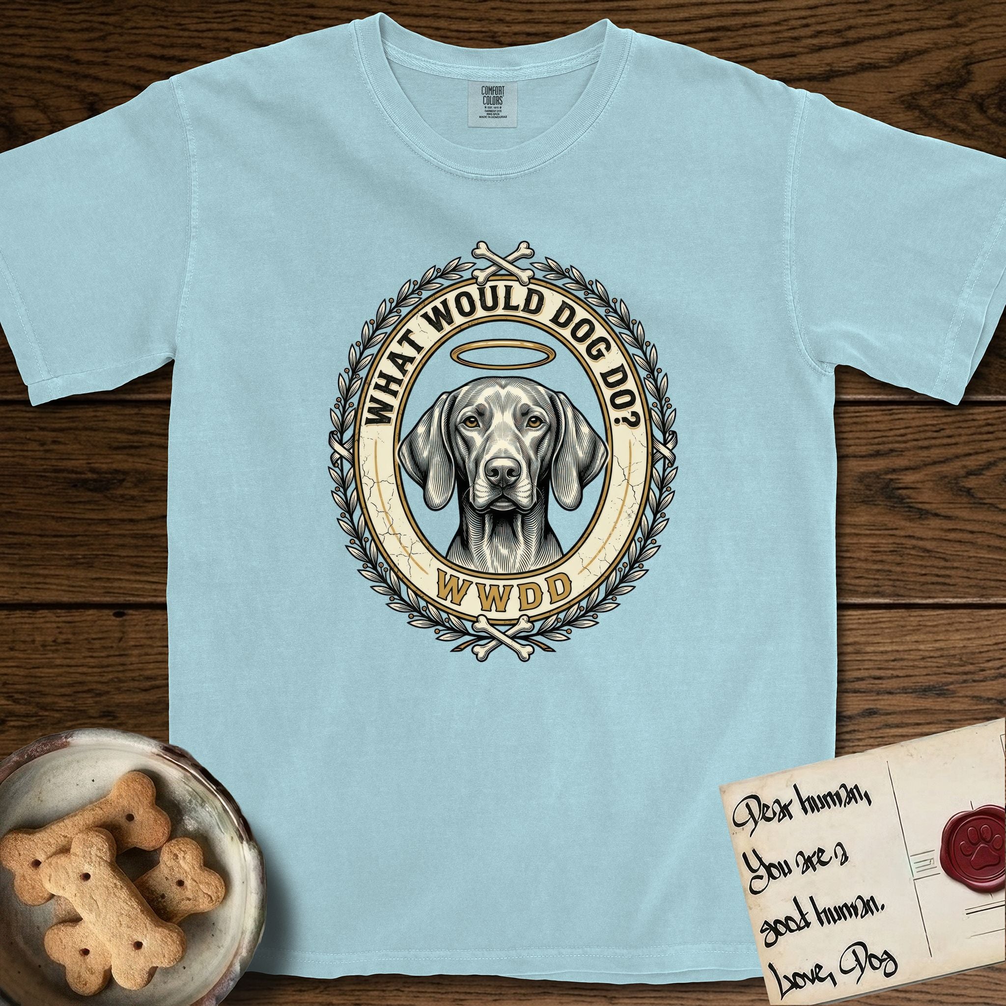 What Would Dog Do Vizsla T-Shirt flat lay in Chambray, featuring a laurel-wreath framed gold portrait medallion of a haloed Vizsla with the question What Would Dog Do.